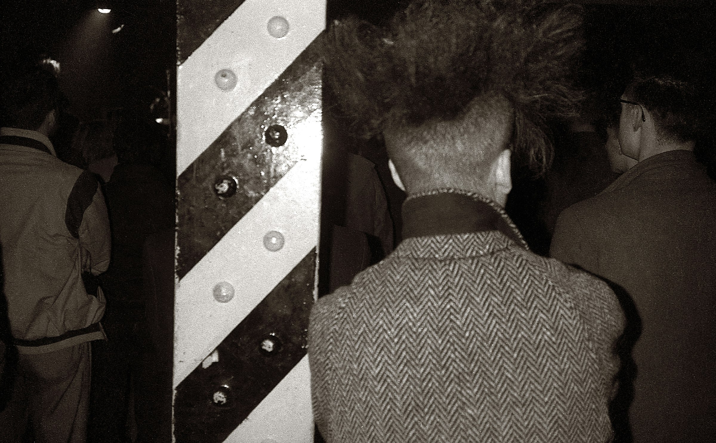 Upturned collars, overcoats, and one of the iconic yellow-and-black columns at the Haçienda in Manchester, circa 1981. Photo by Martin O’Neill/Redferns.
